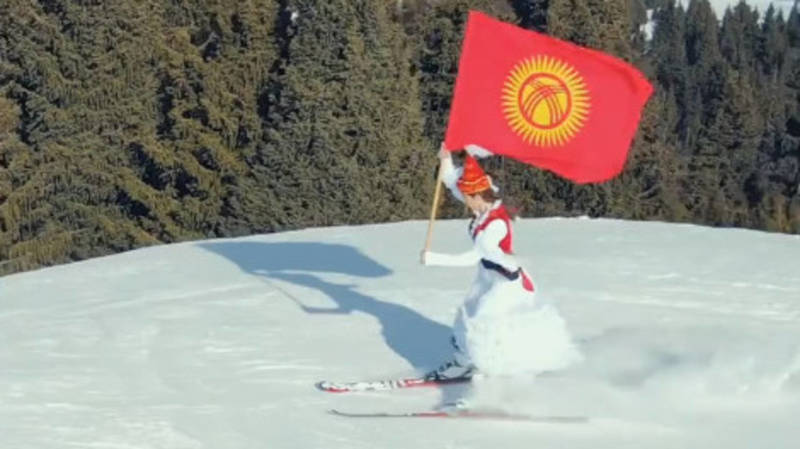 Кыргызстанка скатилась на лыжах с флагом Кыргызстана и в национальном платье. Видео