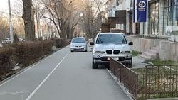 BMW X5 припаркован на тротуаре. Фото