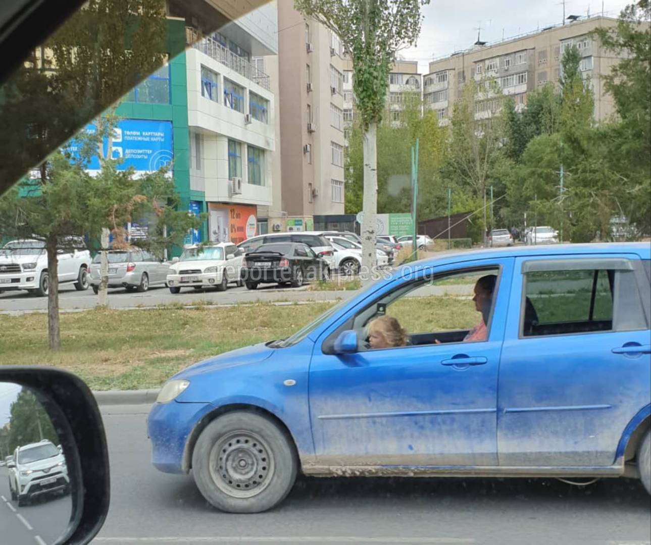 Не пристегнутый ребенок на переднем сидении машины. Фото