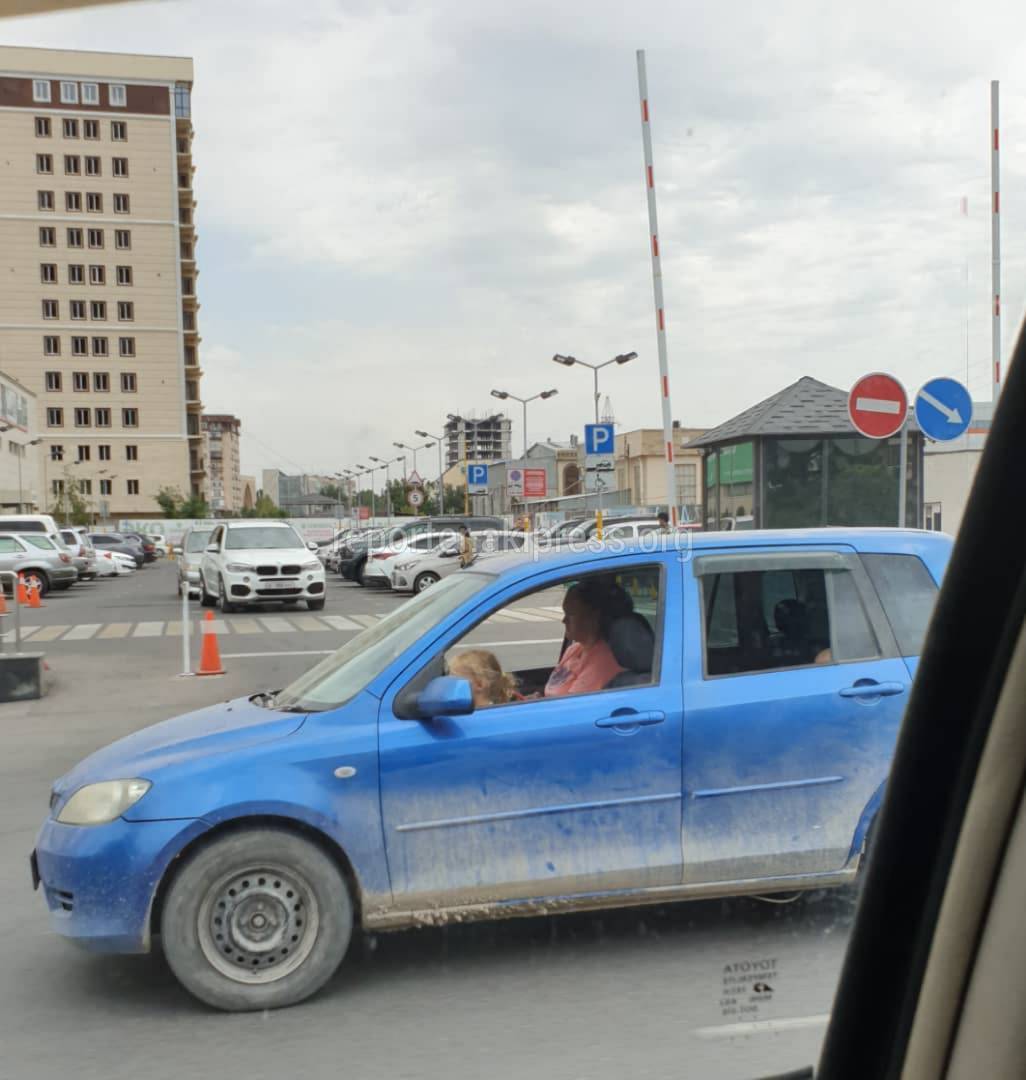 Не пристегнутый ребенок на переднем сидении машины. Фото